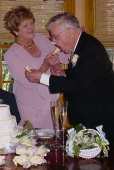 Dad and Evelyn feed each other pieces of wedding cake.