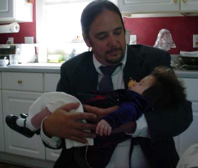 Tian holds Katie in Dad's kitchen.