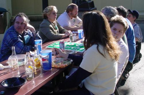 A long table of greens eat together.