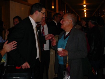 People schmooze in the hall outside his office.