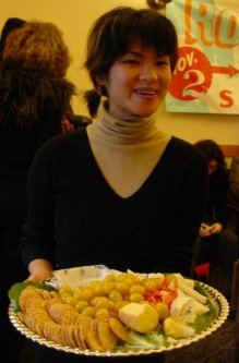 Woman poses with a tray of food.