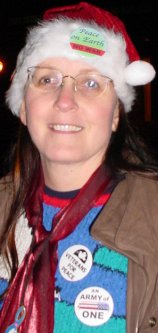 Head shot of woman with some great buttons on her christmasy outfit.