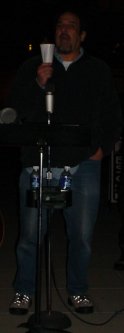 Lenny at the microphone with a candle in his hand.