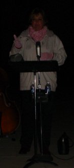 Woman in white coat at the microphone.