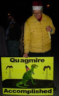 Lennox stands with a sign that says "QUAGMIRE ACCOMPLISHED".
