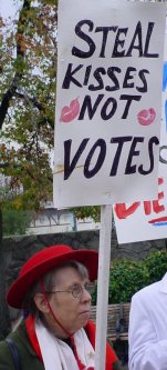 Woman with a sign that reads "Steal kisses not votes".