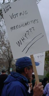 Man with a sign that asks why all the voting irregularities.