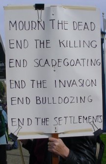 A sign that says END THE SETTLEMENTS.