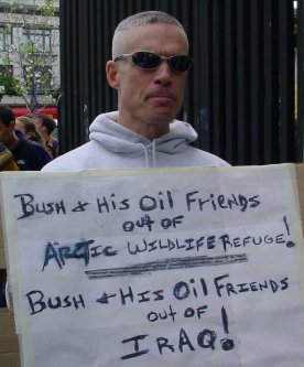A guy in white with a sign saying Bush out of ANWAR