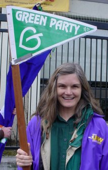 Laura smiles with a Green Party pennant.