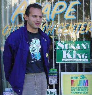 Micheas poses by a Susan King sign on the window of Susan King headquarters.