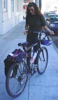 Woman in dark glasses with a nice bicycle lauging at a joke.