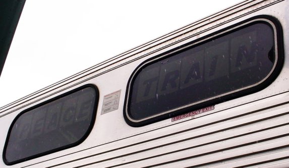 "PEACE TRAIN" is barely visible through the train's windows.
