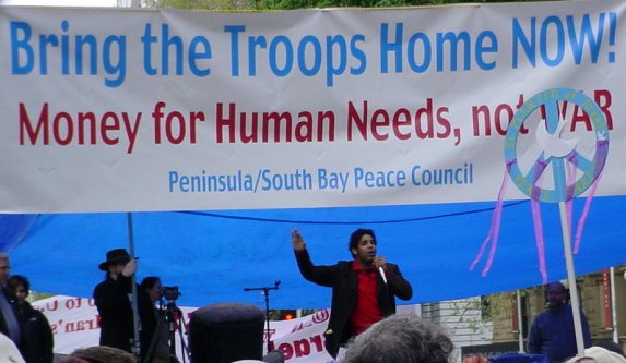 A poet raps under the banner over the stage.