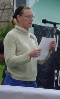 Woman reads notes at the microphone.