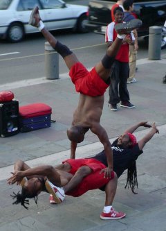 Three Black guys in red pose in an interesting position.