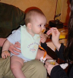 Aiden eats a spoonful of food.