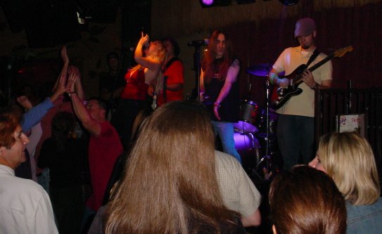 A band plays behind a number of dancers.