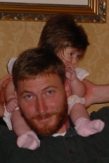 Daddy carries his daughter on his neck.