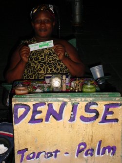 Denise sits with a MEND YOUR FUELISH WAYS sticker.
