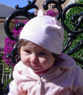 Katie poses in front of a bright purple tree.