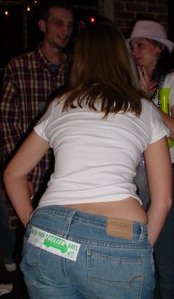 Woman poses with MEND YOUR FUELISH WAYS sticker on her butt.