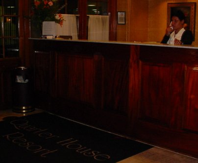 A woman on a phone sits behind a desk.