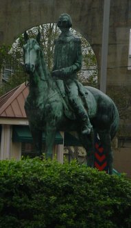 Statue behind a bush.